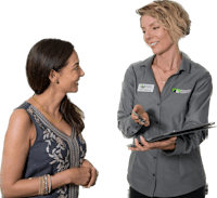 a woman talking to a woman in a grey shirt